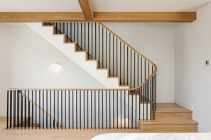 A modern staircase with wooden steps and black railings, leading to an upper floor. - Waterfront Luxury Home Downtown Traverse City (Traverse City)
