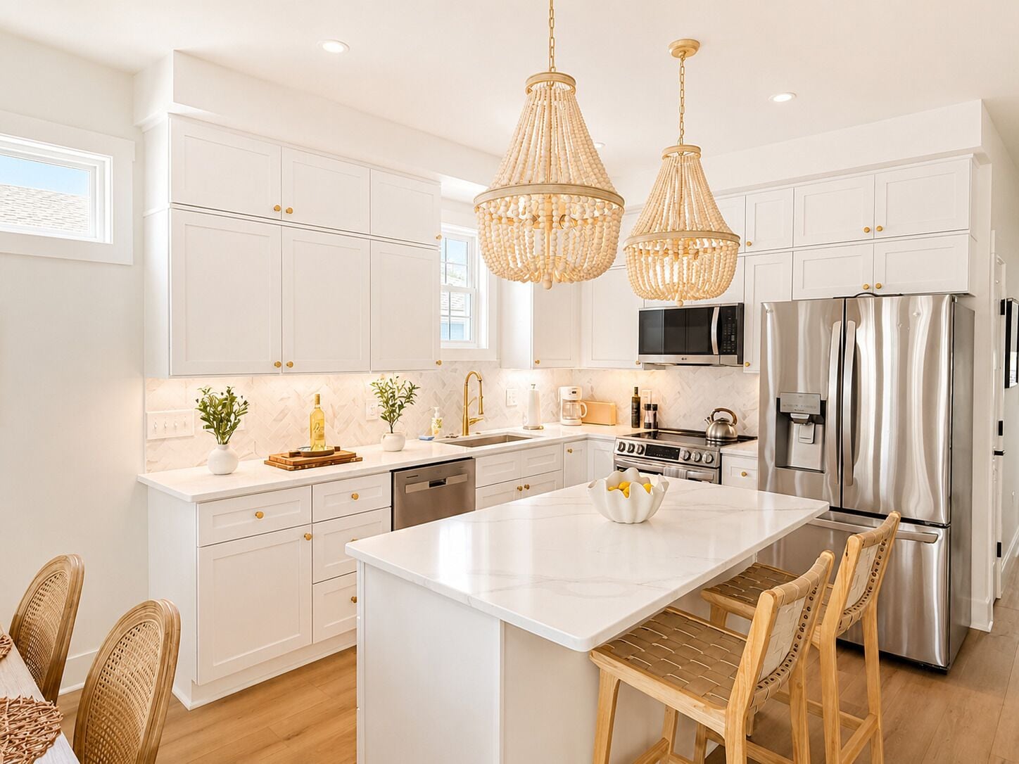 A modern kitchen with white cabinetry, stainless steel appliances, and a central island.