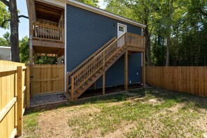 A two-story house with a wooden deck and a staircase leading to the upper level. - TMD Estate. Two Homes. One Private Retreat. Minutes from Downtown and The Beach (Wilmington)