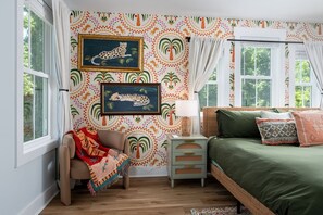 A bedroom with a bed, nightstand, chair, and wall art. - TMD Estate. Two Homes. One Private Retreat. Minutes from Downtown and The Beach (Wilmington)