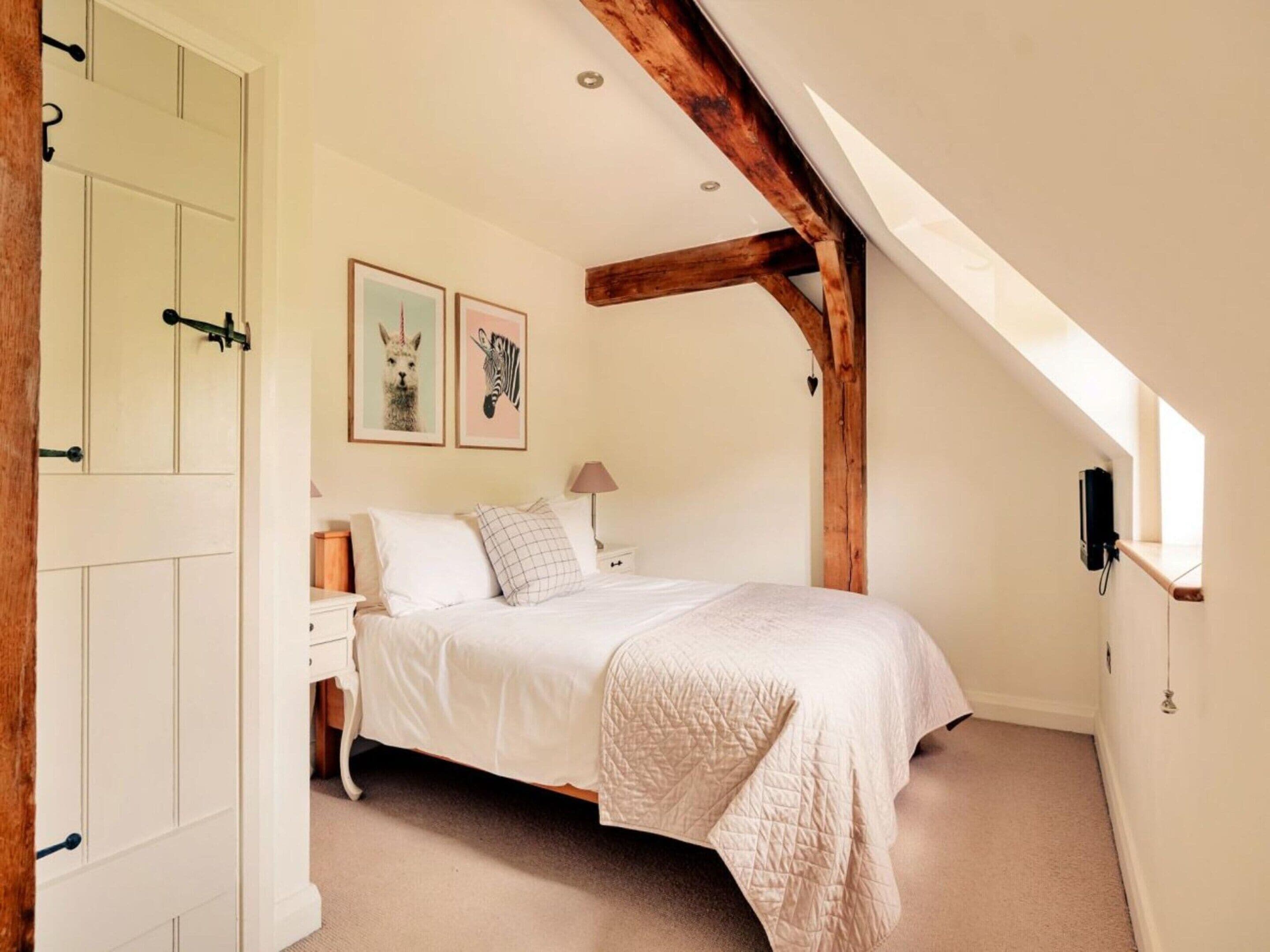 A bedroom with a bed, a nightstand, a lamp, and a wall-mounted heater.