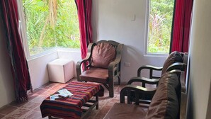A room with a sofa, two chairs, a small table, and a window with curtains. - Casa Verde Panajachel (Panajachel)