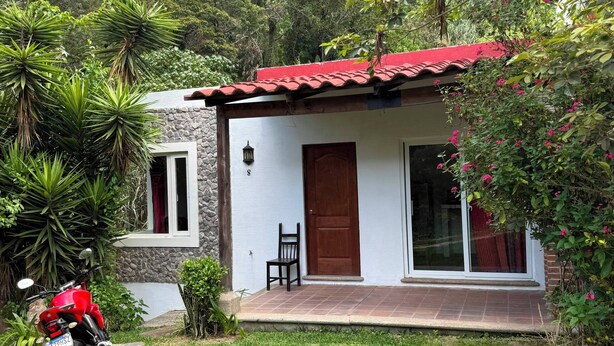 A small house with a red roof, a stone wall, and a paved entrance. - Casa Verde Panajachel (Panajachel)