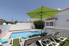 A rooftop pool with lounge chairs and a green umbrella. - Villa Aureo with private pool (La Caleta)