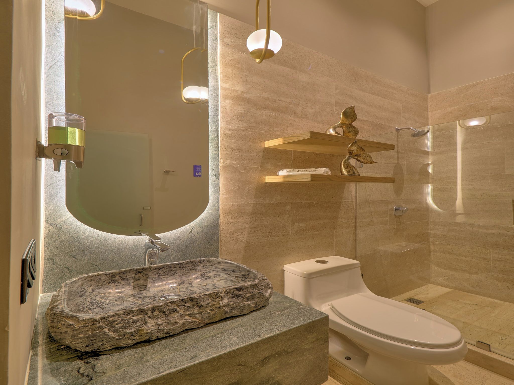 A bathroom with a granite sink, toilet, and a shower area.