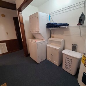A laundry room with a washing machine, dryer, and stacked laundry on a shelf. - Peaceful Retreat at Crawford Farms – Quiet and Comfortable for Work or Relaxing. (Marion)