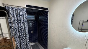 Casa de banho compacta com sanita, lavatório e zona de duche.