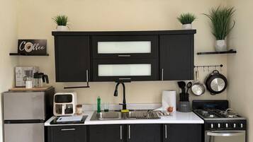 Cafetera o tetera, frigorífico, horno y placa de cocina