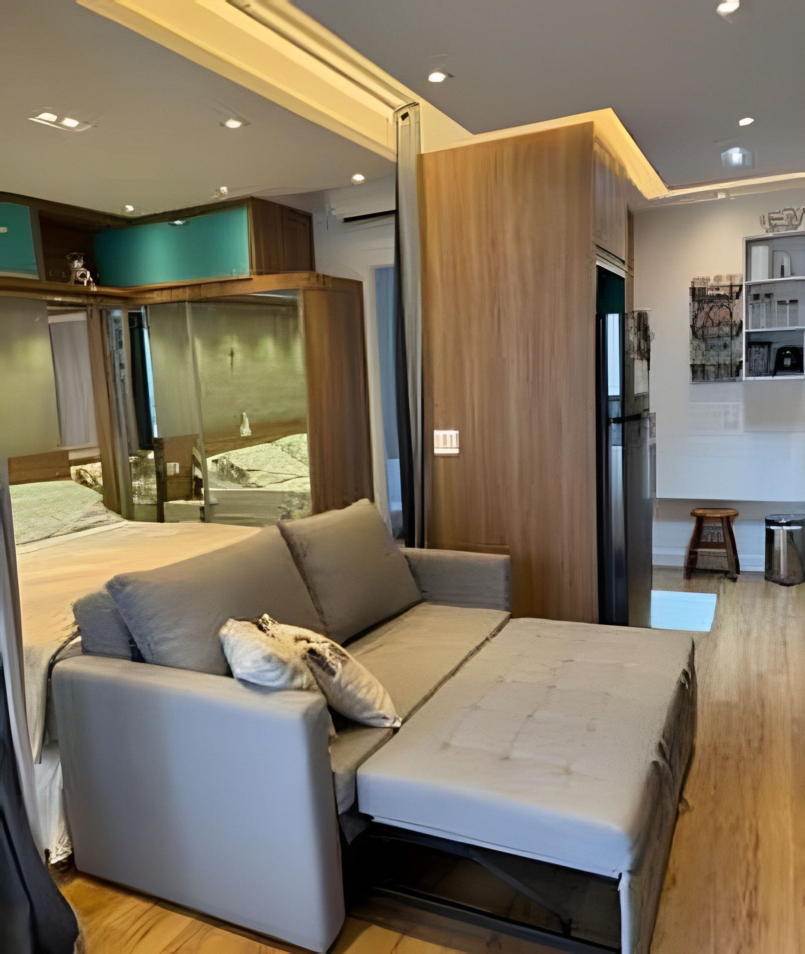 A modern bedroom with a sofa bed, wooden paneling, and a small stool.