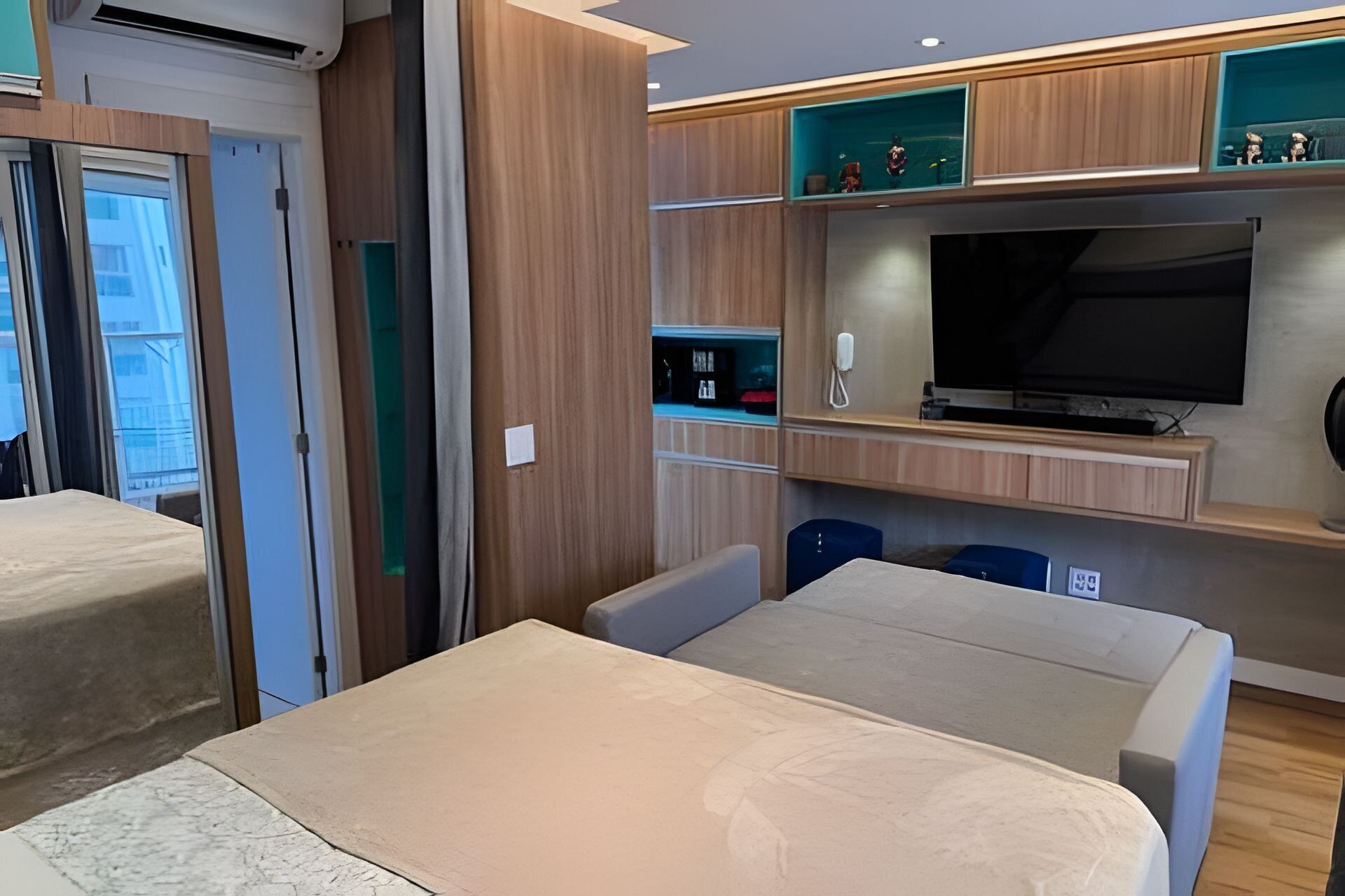 Una habitación de hotel con cama, televisión y minibar.