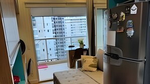 A compact living space with a kitchenette, a bed, a small table, and a view of a cityscape through a large window. - Requintado Studio Paulista Frei Caneca (São Paulo)