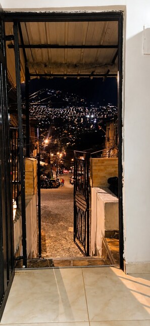 An open doorway leading to a street with a view of a cityscape at night. - Experience the Authentic Colombia at Mi Rincón en Medellin (Medellín)