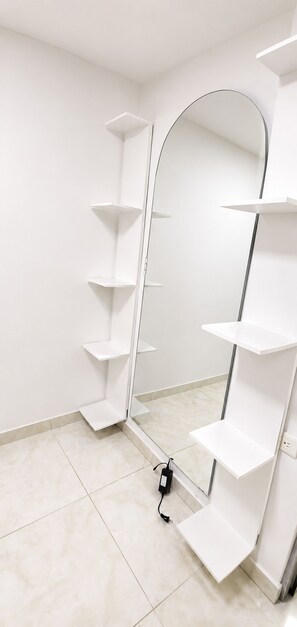 A room with white tiled flooring, a white wardrobe with open doors, and a mirror reflecting the room. - Experience the Authentic Colombia at Mi Rincón en Medellin (Medellín)