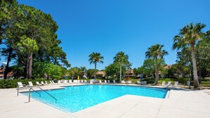 A swimming pool with lounge chairs and palm trees. - Luxury Remodel and New Golf Cart (Miramar Beach)