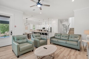 A modern living room with a sofa set, a coffee table, and a ceiling fan. - Ahoy Matey - Emerald Waters (Miramar Beach)
