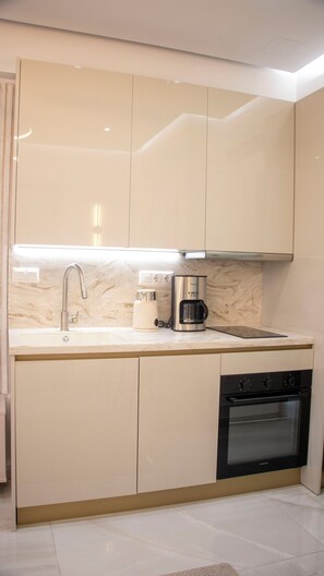 A modern kitchen with a built-in dishwasher, a coffee maker, and a stainless steel faucet.