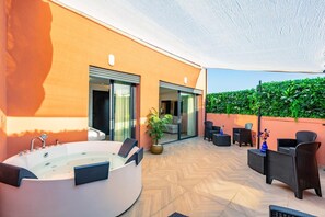 A modern outdoor patio with a hot tub, seating area, and a glass door leading to an interior space. - LUXURY APARTH GUELIZ MARRAKECH AYLAL  (Safi)