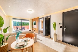 Una sala de estar moderna con un sofá, una mesa de comedor y una planta en maceta.