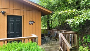 A wooden cabin with a black door, a small porch with chairs, and a sign that reads 'All you need is cozy cabin.' - Mountain Mist Cottage , Valley Views , Sleeps 6 (Sevierville)