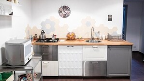 A modern kitchen with a microwave, stove, sink, and cabinets. - CasaMaGà  (Naples)