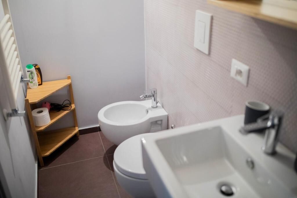 A bathroom with a toilet, bidet, and sink.