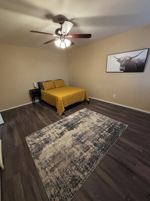 A bedroom with a bed, a ceiling fan, a rug, and a wall-mounted picture. - Hill Country Retreat Minutes to Gruene, Rivers & Canyon Lake (New Braunfels)