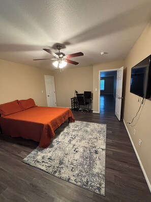 A bedroom with a bed, a desk, a chair, a ceiling fan, and a television. - Hill Country Retreat Minutes to Gruene, Rivers & Canyon Lake (New Braunfels)