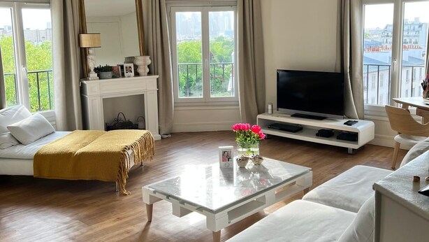 Een moderne woonkamer met een bank, een salontafel, een televisie en een open haard.