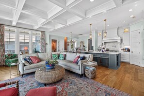 A spacious living room with a large sofa, a coffee table, and a patterned rug. - Canalfront dock, game room and elevator (Surf City)