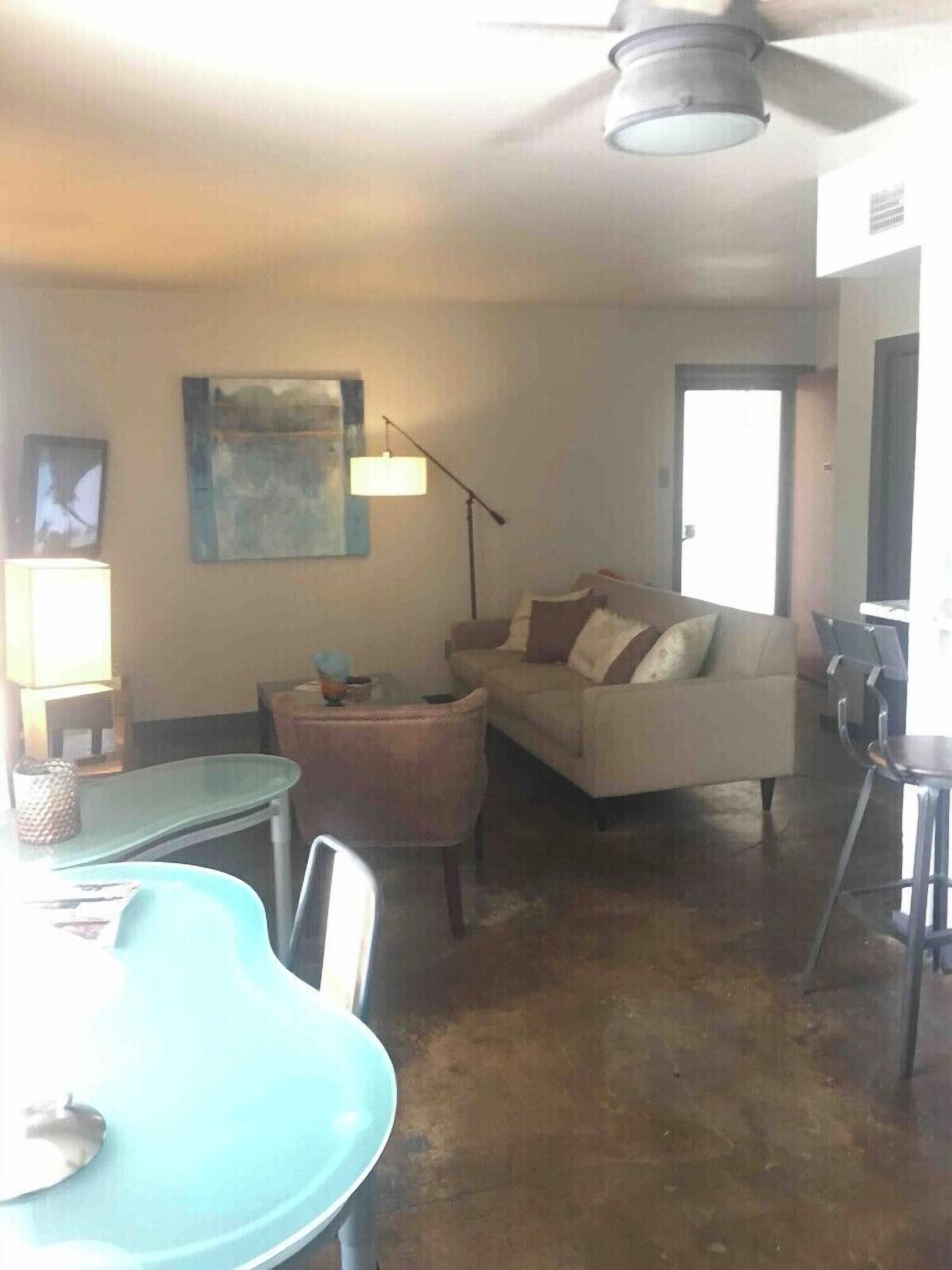 Ein Wohnzimmer mit Sofa, Tisch und Deckenventilator.