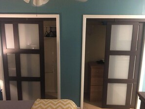 A room with a bed, a wardrobe, and a door leading to another room. - 2720 #104 Oaklawn furnished rental (Dallas)