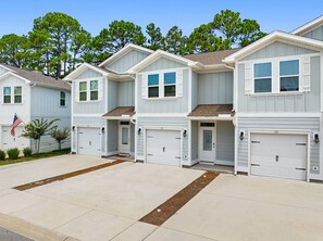 A row of townhouses with attached garages, a clear driveway, and a flag. - Palm Paradise *Minutes to Beach* (SANTA RSA BCH)