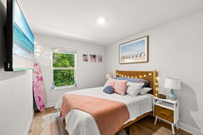 A bedroom with a bed, bedside tables, a window with a view, and wall art. - Palm Paradise *Minutes to Beach* (SANTA RSA BCH)