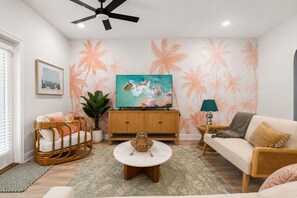 A living room with a television, a sofa, a coffee table, and a ceiling fan. - Palm Paradise *Minutes to Beach* (SANTA RSA BCH)