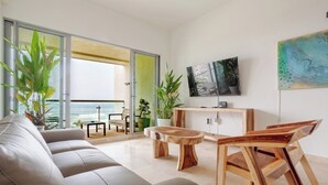 Un soggiorno moderno con un divano, un tavolino in legno e una TV a parete.