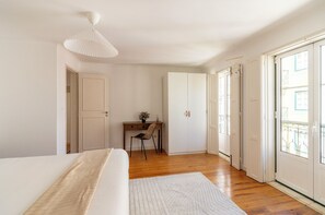 Ein Schlafzimmer mit einem Bett, einem Schreibtisch, einem Stuhl und einem Kleiderschrank.