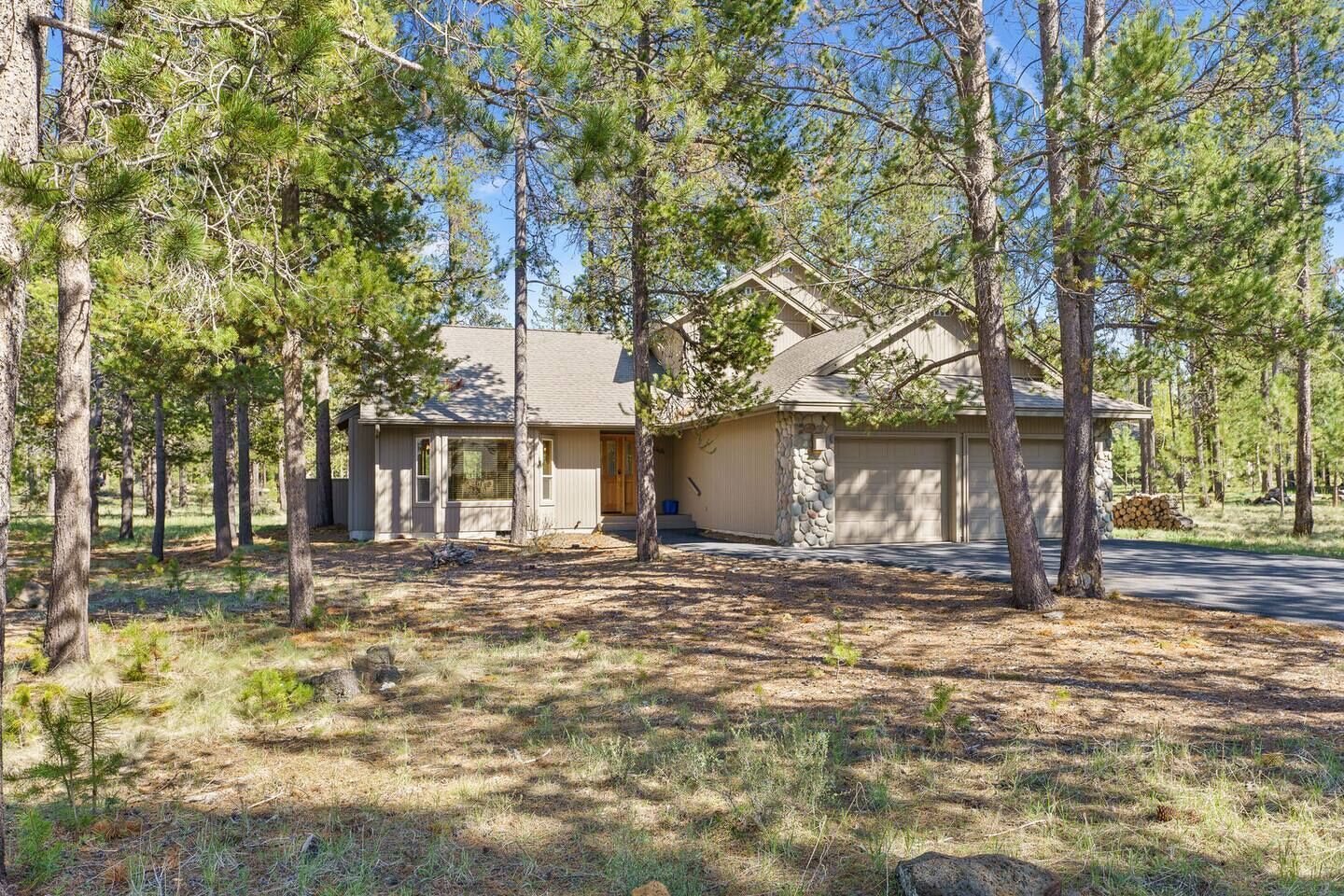 A single-story house with a stone foundation, a garage, and a driveway.