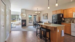 A spacious kitchen with a central island, wooden cabinets, and a built-in fireplace. - Present Pheasant - Cute & Updated, Close to Everything, Golf, Amenities, Perfect For Family (Redmond)