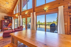 A wooden interior with a large table, red sofa, and a fireplace. - Straight From The Heart (Lyle)