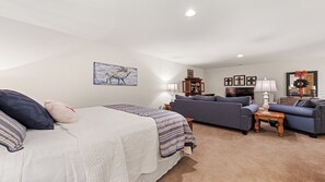 A bedroom with a bed, a sofa, a TV, and a lamp. - Beautiful and comfy mountain view home with outdoor living showcased! (Waynesville)