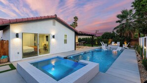 A modern house with a swimming pool, patio furniture, and a well-lit interior. - Zuri Eight - Modern 3BR Oasis w Pool (Indio)