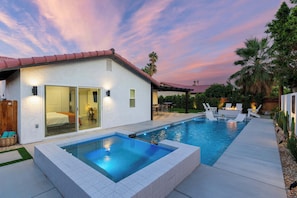 A modern house with a swimming pool, patio furniture, and a well-lit interior. - Zuri Eight - Modern 3BR Oasis w Pool (Indio)