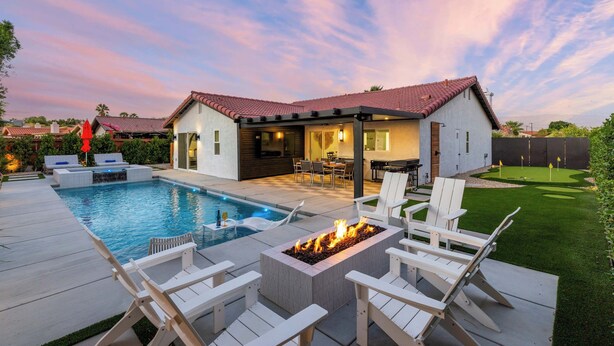 A backyard with a swimming pool, fire pit, and outdoor seating area. - Zuri Eight - Modern 3BR Oasis w Pool (Indio)