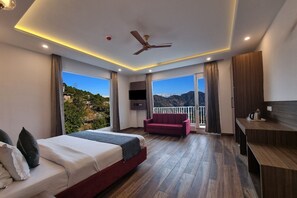 A modern hotel room with a large bed, a sofa, a desk, and a balcony with a mountain view. - Hotel Luxe Vista Dalhousie (Dalhousie)