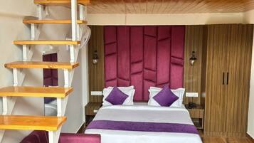 A bedroom with a wooden staircase, a bed with a headboard, and a wardrobe.