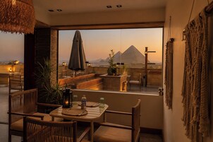 Ein Essbereich mit Blick auf eine Pyramide, Holzmöbel und einer hängenden Lampe.