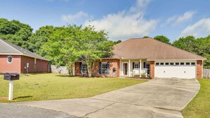 A residential house with a brick exterior, a garage, and a front yard. - 6BR Family Home Near Twin Hills Fire Pit (Crestview)