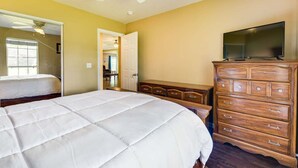 A bedroom with a bed, a dresser, a television, and a ceiling fan. - 6BR Family Home Near Twin Hills Fire Pit (Crestview)