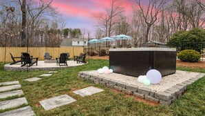 A backyard with a fire pit, outdoor seating, and a shed. - Greensboro Getaway Villa (Greensboro)