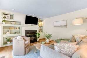 A modern living room with a fireplace, a television, and a sofa. - Arlington Oasis 7 Br (Jamestown)